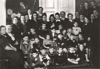 Tallinn - 1940 - Fanny Dubovski Jewish Kindergarten
Left to right.
At the top right corner: Tsila Manoim, Hasin
Parents: Rocha Zimbalov, ?, ?, Rosa Piel, Rocha Klutschik, Umov, Sara Blum, ?, Sonja Beilinson, ?, ?,  Efraim Rochlin,  Hena Aronovitsch, Dr Ring, ?, Fanni Dubovski, Goldmann, ?
Children:
Sitting on the floor: ?, Isak Beilinson, Gabi Piel, Nata Ring, Buba Goldmann, Lia Goldmann
Sitting on the chairs: Gabi Manoim, ?, Ranja Manoim (Blum), ?, Benno Haitin, ?
Standing: Faivi Klutschik, Ruti Ring, Lia Rogovski, Wulf Umov, Lia Zaks, Schloma Aronovitsch, Abi Hasin, Slomka 
