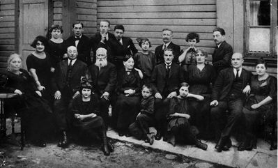 Hoff family. See same picture here http://muuseum.jewish.ee/Gallery1/displayimage.php?pid=2441
The girl standing in the middle - Lina Hoff (Maisel), at left from Lina stands her brother Konstantin (Konzi) Maisel.
Sitting IV from right - Jacob Maisel and III from right his wife Rebekka Maisel (Josselov). Before them I from right is their daughter Ester Kamuscher (Maisel).
