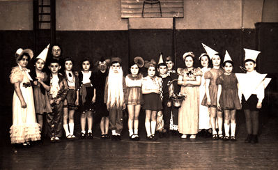 Tallinn - 1938. Purim in Tallinn Jewish school.  1A class. 1938.
Left to right: Dori Scheskin, ?, Jascha Gordon?, the teacher Hatskin, Juza Rubinstein, Ita Slatkin, Njoma ?, Lev (Haim) Judeikin,  Mia ?, Lia Braschinsky, Jossi Pakin, Henni Lipelis, Lilly Schulmann,  Sara Mirvits? Vasser?, ?, Borja Gurevitsch? 
